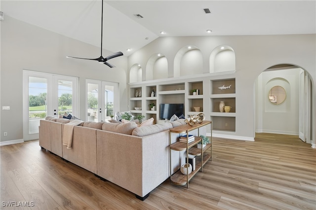 12006 Cypress Links Dr, Fort Myers, FL 33913 - living room with built in features, french doors, arched walkways, high vaulted ceiling, and light wood finished floors