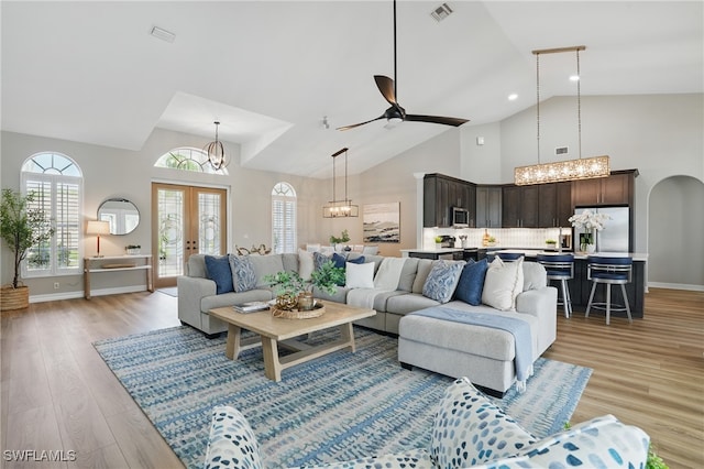 12006 Cypress Links Dr, Fort Myers, FL 33913 - living room with a chandelier, high vaulted ceiling, light wood-type flooring, french doors, and a ceiling fan