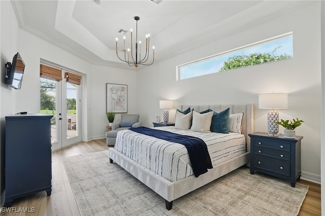 12006 Cypress Links Dr, Fort Myers, FL 33913 - bedroom with access to exterior, a chandelier, a tray ceiling, french doors, and light wood finished floors