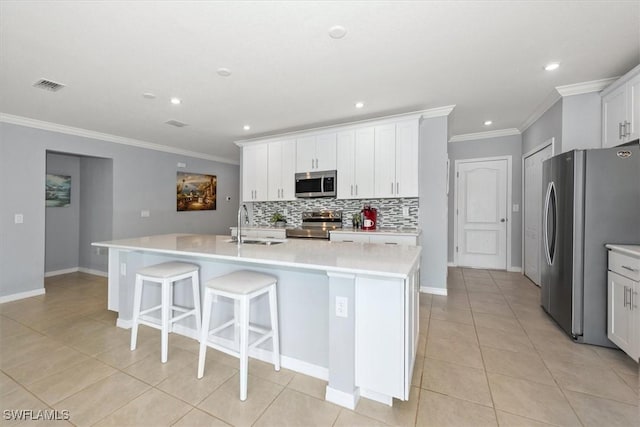 8959 Cascade Price Cir, North Fort Myers, FL 33917 - kitchen featuring stainless steel appliances, ornamental molding, backsplash, a center island with sink, and light tile patterned floors