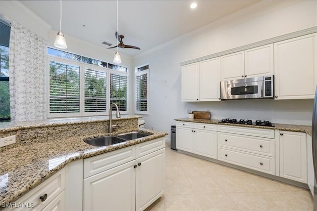 29120 Brendisi Way Unit 102, Naples, FL 34110 - kitchen featuring crown molding, white cabinetry, light stone counters, stainless steel microwave, and light tile patterned floors