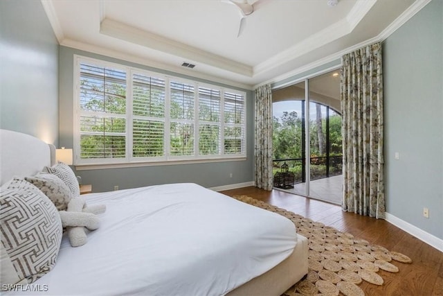 29120 Brendisi Way Unit 102, Naples, FL 34110 - bedroom with multiple windows, access to exterior, hardwood / wood-style floors, a raised ceiling, and crown molding