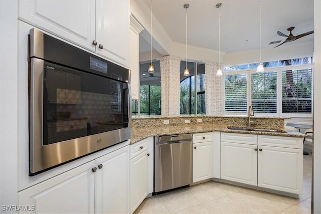 29120 Brendisi Way Unit 102, Naples, FL 34110 - kitchen featuring stainless steel dishwasher, oven, white cabinets, light stone countertops, and light tile patterned flooring