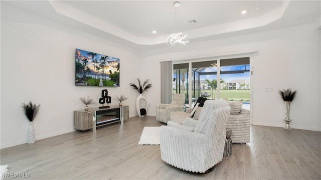 15898 Sugar Hill Dr, Punta Gorda, FL 33982 - living area featuring a raised ceiling, light wood-style floors, recessed lighting, and a glass covered fireplace