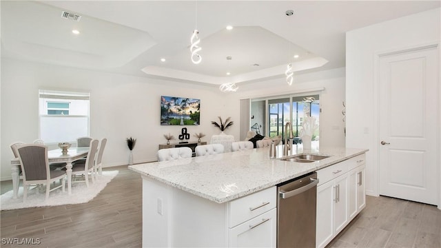 15898 Sugar Hill Dr, Punta Gorda, FL 33982 - kitchen featuring dishwasher, a tray ceiling, an island with sink, white cabinets, and light stone counters