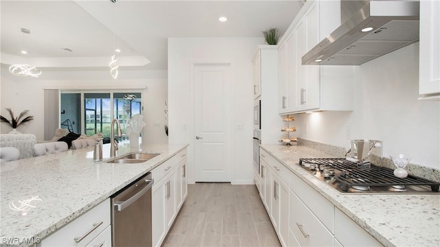 15898 Sugar Hill Dr, Punta Gorda, FL 33982 - kitchen with wall chimney range hood, appliances with stainless steel finishes, white cabinets, recessed lighting, and open floor plan