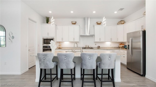 15898 Sugar Hill Dr, Punta Gorda, FL 33982 - kitchen with appliances with stainless steel finishes, wall chimney exhaust hood, a center island with sink, white cabinets, and recessed lighting