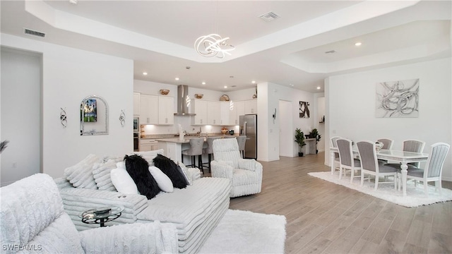 15898 Sugar Hill Dr, Punta Gorda, FL 33982 - living area featuring a raised ceiling, a chandelier, light wood-style flooring, and recessed lighting
