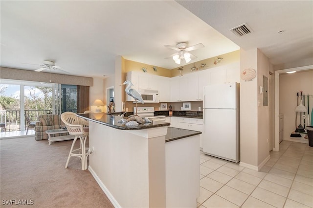 22724 Island Pines Way Unit 101, Fort Myers Beach, FL 33931 - kitchen featuring a ceiling fan, dark countertops, white appliances, and a peninsula