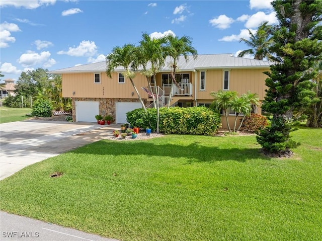 24398 Treasure Island Blvd, Punta Gorda, FL 33955 - view of front of property featuring stairway, concrete driveway, a garage, and a metal roof