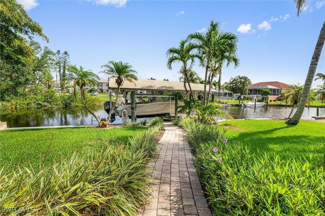 24398 Treasure Island Blvd, Punta Gorda, FL 33955 - view of home's community with boat lift, a dock, a water view, and a lawn