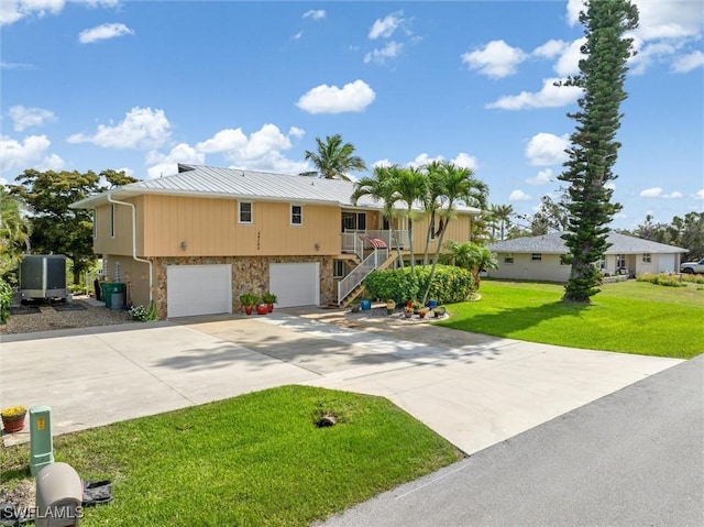 24398 Treasure Island Blvd, Punta Gorda, FL 33955 - view of front of property featuring stairway, stone siding, driveway, a garage, and a front yard
