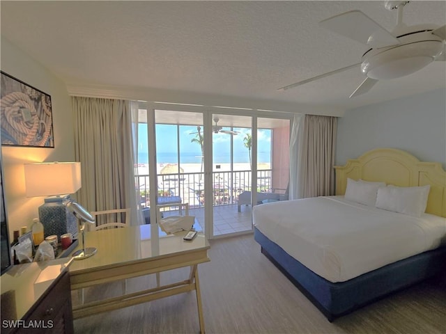 140 Estero Blvd Unit 2206, Fort Myers Beach, FL 33931 - bedroom with access to outside, wood finished floors, a textured ceiling, a ceiling fan, and an office area