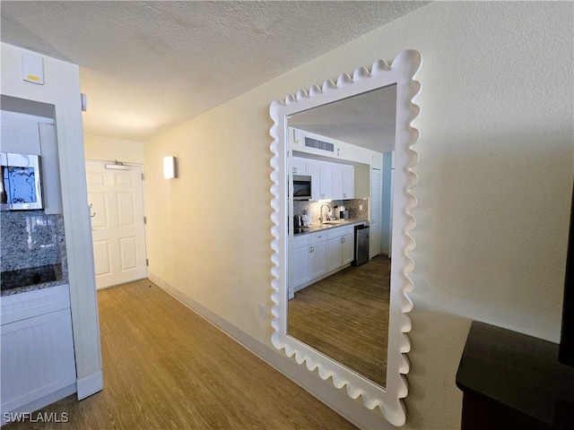 140 Estero Blvd Unit 2206, Fort Myers Beach, FL 33931 - hall with wood finished floors and a textured ceiling