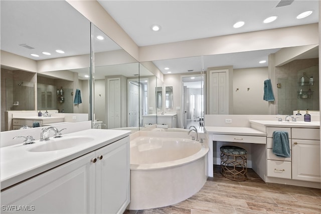 19671 Marino Lake Cir Unit 1602, Miromar Lakes, FL 33913 - bathroom with a garden tub, two vanities, a tile shower, and recessed lighting