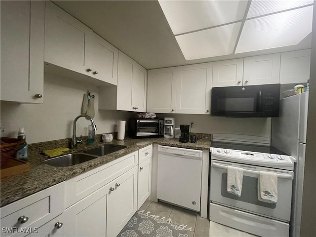 3706 Broadway Unit 27, Fort Myers, FL 33901 - kitchen featuring white appliances, white cabinetry, dark stone countertops, and light tile patterned floors