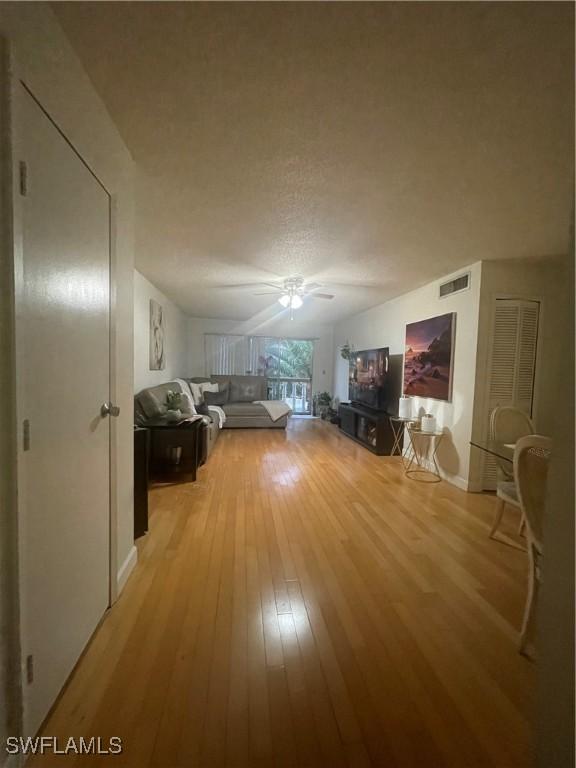 3706 Broadway Unit 27, Fort Myers, FL 33901 - living area featuring light wood-type flooring, ceiling fan, and a textured ceiling