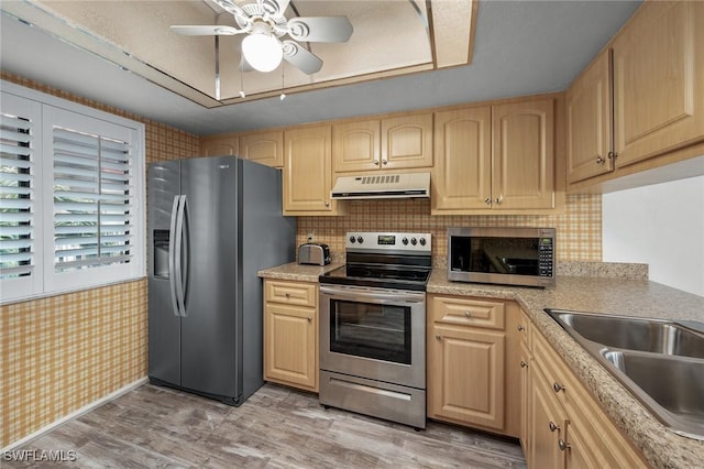 11140 Caravel Cir Unit 306, Fort Myers, FL 33908 - kitchen with stainless steel appliances, light brown cabinets, ceiling fan, light wood-style flooring, and under cabinet range hood