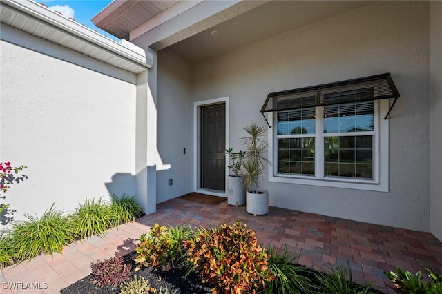 10581 Woodchuck Ln, Bonita Springs, FL 34135 - entrance to property with stucco siding and a patio area