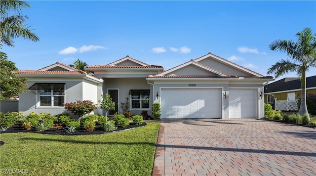 10581 Woodchuck Ln, Bonita Springs, FL 34135 - view of front facade with decorative driveway, stucco siding, a garage, a front lawn, and a tile roof