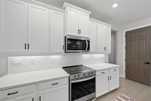 10581 Woodchuck Ln, Bonita Springs, FL 34135 - kitchen with stainless steel appliances, light countertops, decorative backsplash, white cabinetry, and recessed lighting