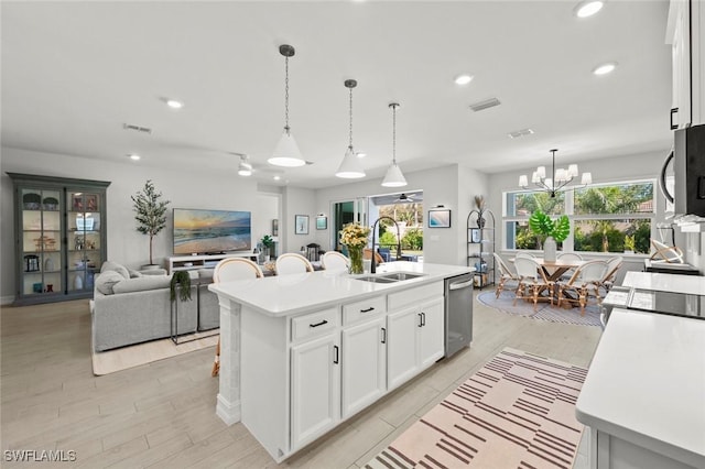 10581 Woodchuck Ln, Bonita Springs, FL 34135 - kitchen featuring light countertops, white cabinets, hanging light fixtures, a chandelier, and a center island with sink