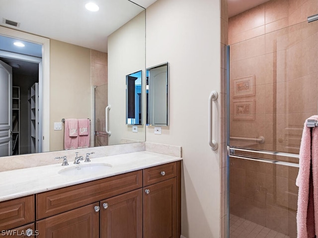 5051 Pelican Colony Blvd Unit 401, Bonita Springs, FL 34134 - bathroom featuring a stall shower, vanity, recessed lighting, and a walk in closet