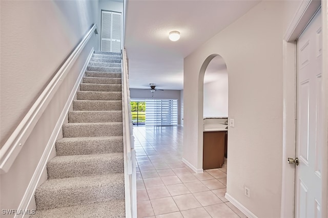 10058 Pacific Pines Ave, Fort Myers, FL 33966 - staircase with tile patterned flooring, arched walkways, and a ceiling fan