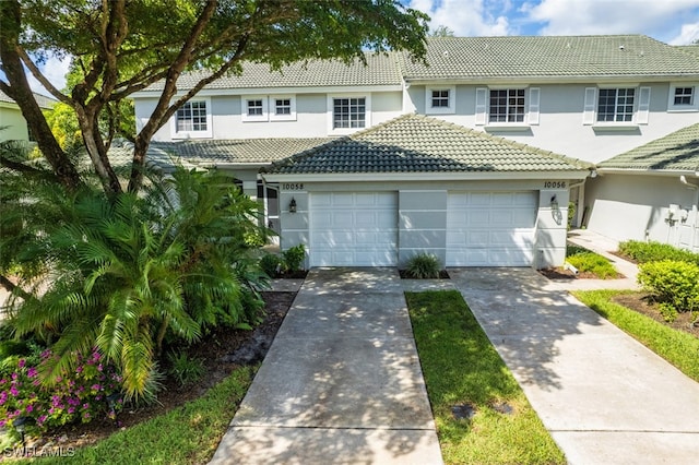10058 Pacific Pines Ave, Fort Myers, FL 33966 - view of front of property featuring stucco siding, a tiled roof, a garage, and driveway