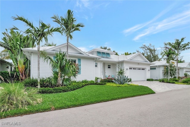 2120 Curtis St, Naples, FL 34112 - view of front of home with an attached garage, decorative driveway, and a front lawn