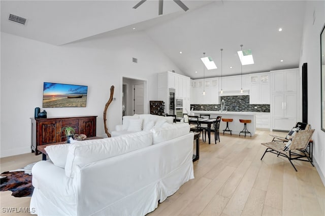 2120 Curtis St, Naples, FL 34112 - living room with a skylight, high vaulted ceiling, light wood-type flooring, a ceiling fan, and recessed lighting