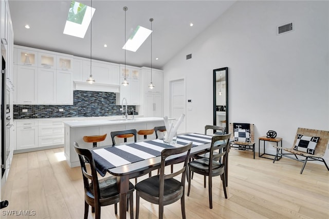 2120 Curtis St, Naples, FL 34112 - dining room with a skylight, light wood-style flooring, high vaulted ceiling, and recessed lighting