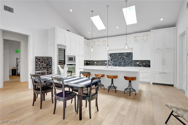 2120 Curtis St, Naples, FL 34112 - dining room featuring a skylight, light wood-style floors, recessed lighting, and high vaulted ceiling