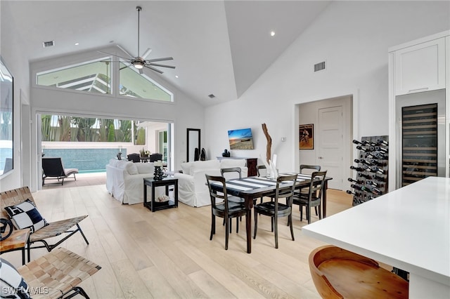 2120 Curtis St, Naples, FL 34112 - dining space featuring high vaulted ceiling, wine cooler, ceiling fan, light wood-type flooring, and healthy amount of natural light