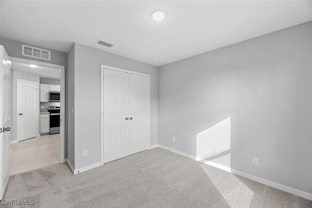 2816 27th St SW, Lehigh Acres, FL 33976 - unfurnished bedroom featuring light colored carpet and a closet