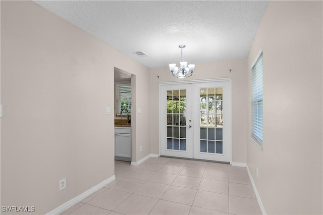 1141 S Alhambra Cir, Naples, FL 34103 - unfurnished dining area featuring a chandelier, french doors, a textured ceiling, and light tile patterned flooring