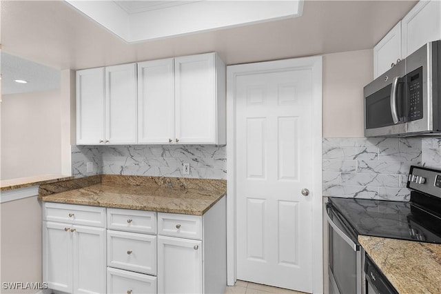 1141 S Alhambra Cir, Naples, FL 34103 - kitchen featuring stainless steel appliances, white cabinets, light stone counters, and decorative backsplash