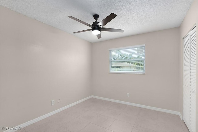 1141 S Alhambra Cir, Naples, FL 34103 - unfurnished bedroom with a textured ceiling, a closet, light tile patterned floors, and a ceiling fan