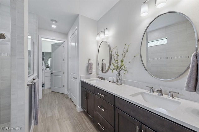 2703 Aviamar Cir, Naples, FL 34114 - bathroom featuring double vanity, wood finished floors, and tiled shower