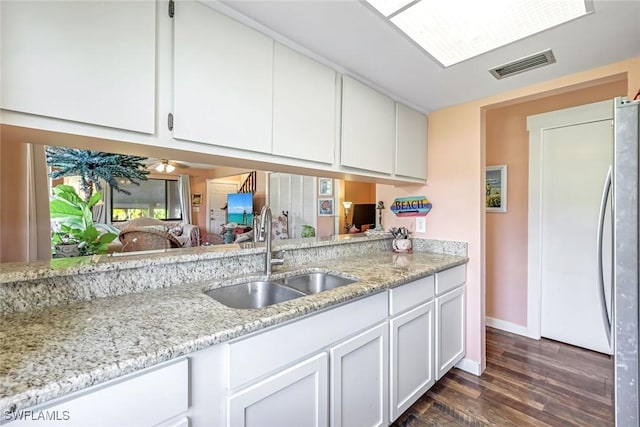 13532 Siesta Pines Ct Unit 5, Fort Myers, FL 33908 - kitchen featuring stainless steel refrigerator, white cabinets, dark wood-style flooring, and light stone countertops