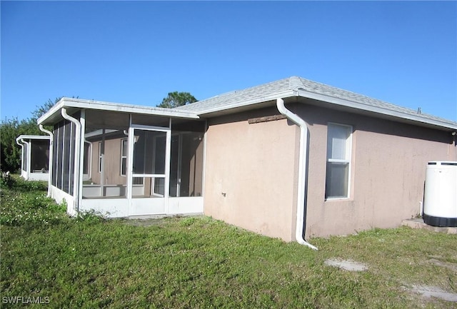 1568/1570 Gilbert Ave S, Lehigh Acres, FL 33973 - rear view of property with a sunroom, stucco siding, and a lawn