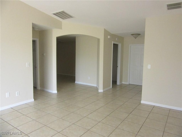 1568/1570 Gilbert Ave S, Lehigh Acres, FL 33973 - spare room featuring arched walkways and light tile patterned flooring