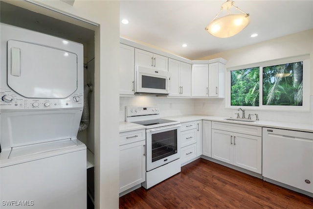 4160 Crayton Rd Unit A8, Naples, FL 34103 - kitchen with white appliances, stacked washing machine and dryer, white cabinets, light countertops, and dark wood-style floors
