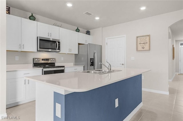 1700 SW 3rd St, Cape Coral, FL 33991 - kitchen featuring appliances with stainless steel finishes, arched walkways, a kitchen island with sink, white cabinetry, and recessed lighting