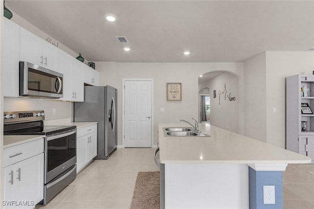 1700 SW 3rd St, Cape Coral, FL 33991 - kitchen featuring stainless steel appliances, arched walkways, a kitchen island with sink, light countertops, and white cabinets
