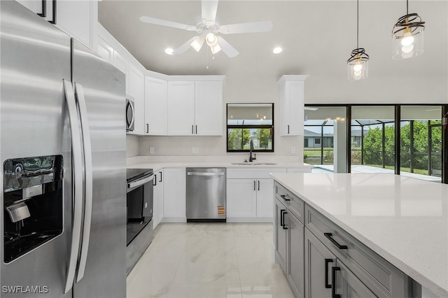 2510 SW 17th Ave, Cape Coral, FL 33914 - kitchen with appliances with stainless steel finishes, ceiling fan, decorative light fixtures, light marble finish flooring, and white cabinets
