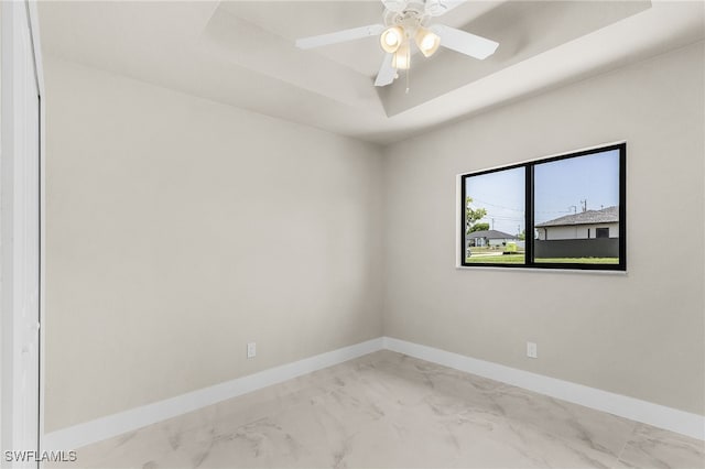 2510 SW 17th Ave, Cape Coral, FL 33914 - empty room with marble look tiles, a tray ceiling, and a ceiling fan