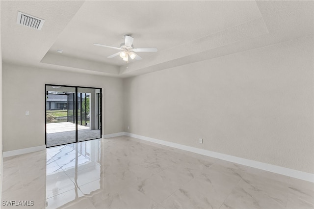 2510 SW 17th Ave, Cape Coral, FL 33914 - empty room featuring a raised ceiling, light marble finish floors, and a ceiling fan