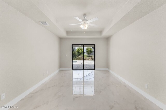 2510 SW 17th Ave, Cape Coral, FL 33914 - empty room featuring light marble finish flooring, a ceiling fan, and a raised ceiling