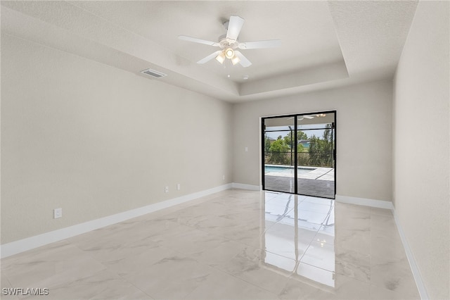 2510 SW 17th Ave, Cape Coral, FL 33914 - unfurnished room featuring light marble finish flooring, a ceiling fan, and a tray ceiling